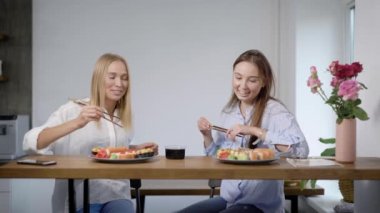 iki genç neşeli arkadaşları kadın içinde yemek suşi ve temaki evinde akşam yiyorsun, gülümsüyor musun