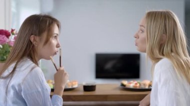 iki kız arkadaş sohbet ve teslimat hizmeti üzerinden suşi yemek evi, odada dedikodu
