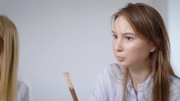 Loira e morena jovens estudantes meninas estão desfrutando de sushi e temaki em um jantar em casa, eles estão conversando — Vídeo de Stock