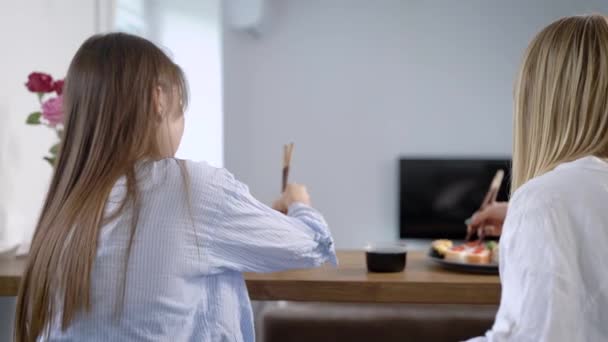 Женщина ест суши и смотрит на друзей — стоковое видео