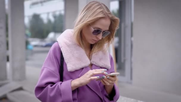 Mujer con estilo usando teléfono inteligente en la calle — Vídeo de stock