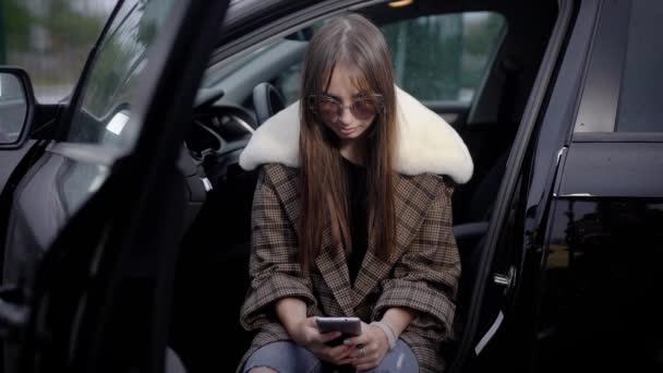 Jeune femme utilisant un smartphone en voiture — Video