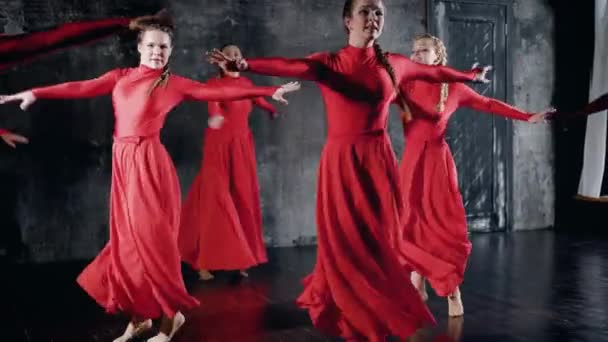 Ballet moderno realizado por siete bailarines. Chicas en vestidos rojos realizan de forma sincrónica elementos de baile — Vídeo de stock