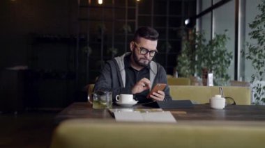 Kafede masada Smartphone kullanan adam