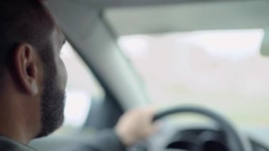 Genç adam araba kullanıyor. 