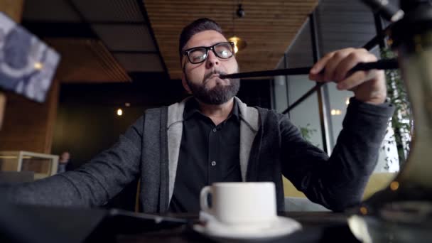 Man smoking at table in cafe — Stock Video