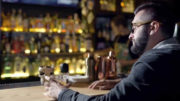 Hombre con vaso de bebida en el mostrador de bar — Vídeos de Stock