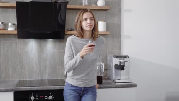 Молодая женщина со стаканом напитка за столом — стоковое видео