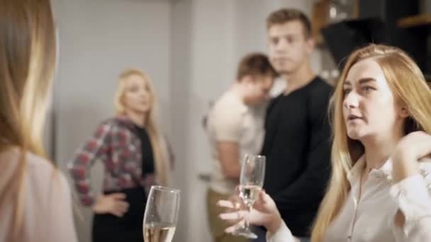 Young people with glasses of champagne talking and preparing in kitchen — Stock Video