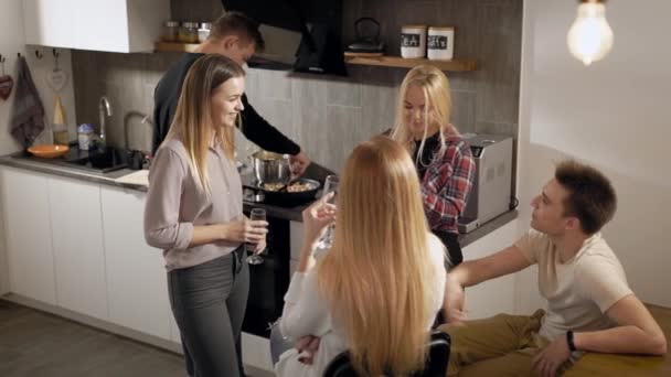Jovens com copos de bebidas na cozinha — Vídeo de Stock