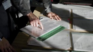 Mühendisleri şirketteki yeni parçalar çizimlerinin görüşüyorlar. Çizimler işçiler için yazıcıda yazdırılır.