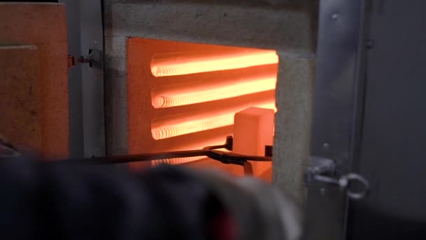 Loja de tratamento térmico. Parte de metal quente em pinças especiais — Vídeo de Stock