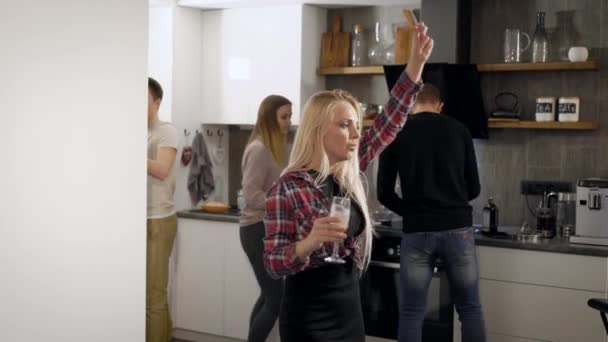 つの金髪の若い女性が彼らの友人は 楽しいエンターテイメントとシャンパンを飲む大学の部屋でパーティ キッチンで踊っています — ストック動画