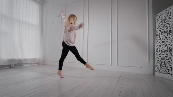 Atletisk flicka dansar med en bunden rosett på hennes hand. — Stockvideo