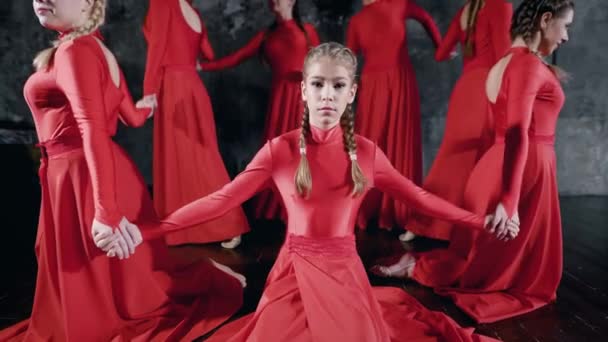 Beaucoup de jeunes filles talentueuses en rouge exécutant une danse, des mouvements rythmiques passionnés . — Video