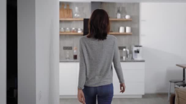 Chica morena regando plantas en casa, cuidando de las plantas caseras . — Vídeos de Stock