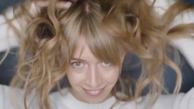 Mutlu gülümseyen kız bir güzellik stüdyosu poz güzel sarışın kıvırcık saçlı.