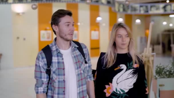 Freudiger junger Mann und Frau nähern sich der netten Gastgeberin einer Cafeteria in einem Food Court des großen Einkaufszentrums — Stockvideo