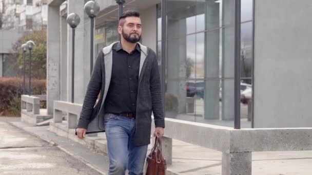 Homem adulto confiante está vestindo estilo casual e carregando bolsa está passeando na rua da cidade no dia de outono — Vídeo de Stock