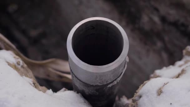 Велика сталева труба промислового обладнання зафіксована на замерзлому ґрунті на відкритому повітрі, камера рухається навколо — стокове відео