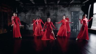 yedi büyüleyici dansçılar kadınlar dans salonu prova, kırmızı elbiseler giyen, yerde yatarken