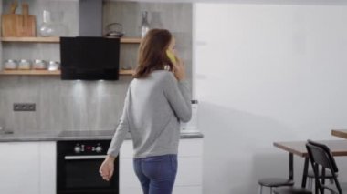Genç ince kadın gülümsüyor, bitmiş çağrı tarafından cep telefonu evinde akşam saat yürüyüş konuşuyor