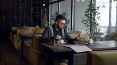 Cafe ve yeşil çay ile oturan yakışıklı condfident adam.