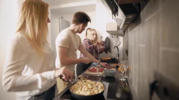 Vista lateral de amigos cozinhando todos juntos na cozinha, comida saborosa para a noite . — Vídeo de Stock