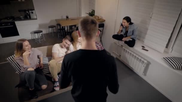 Heureux adolescents souriants jouant des charades dans le salon, jeu amusant pour une fête . — Video