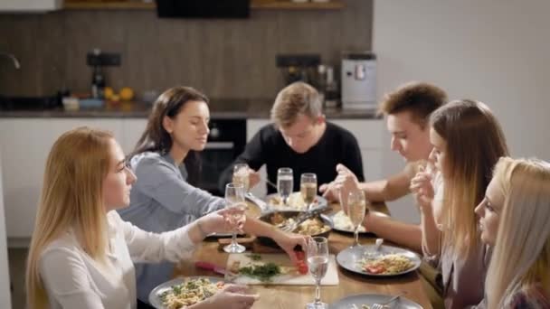 Gelukkige jonge mensen aan tafel in de keuken — Stockvideo