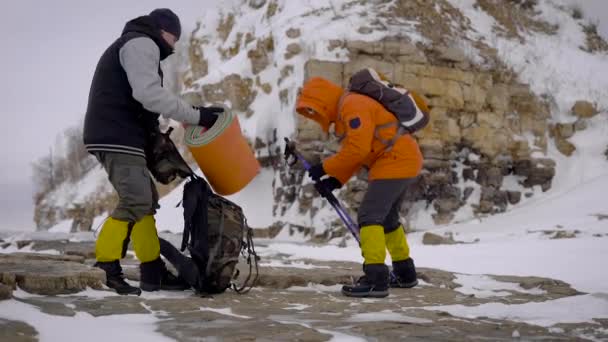 Twee vrienden herverpakken trekking apparatuur na rust — Stockvideo