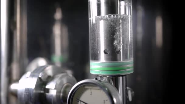 Небольшой стеклянный цилиндр с бесцветной жидкостью — стоковое видео