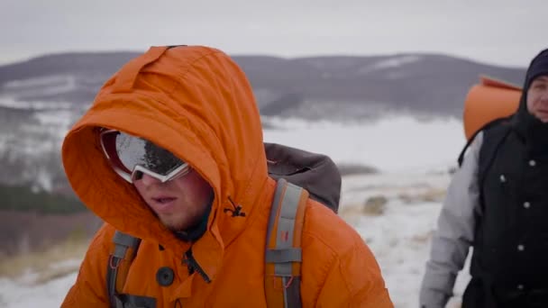 Vue de face de deux voyageurs faisant de la randonnée en hiver . — Video