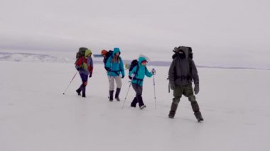 Trekking ekipmanları ve kayak direkleri ile iki erkek ve kadın.