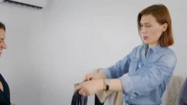 İki kadın kız arkadaş gardırobu söker. Kızlar farklı giysiler deneyin ve nasıl giyinmek karar.