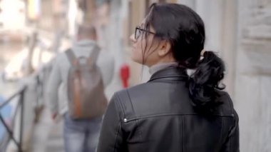 İtalyan Venedik'te deri ceketli güzel bir kız yürüyor. Kadın turist Avrupa'daki tatilinden memnun.