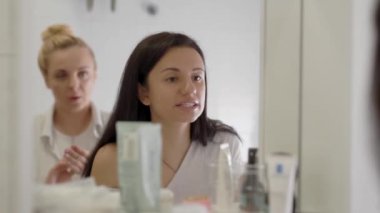 Bir ayna önünde dudaklarına ruj uygulayan Büyüleyici esmer kadın, sabah makyaj rutin.