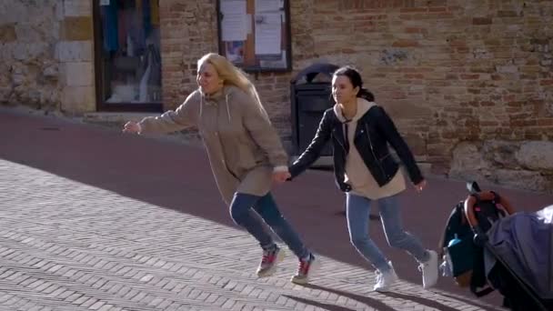 Femei copilărești ținându-se de mână și traversând strada alergând, distracție zi împreună . — Videoclip de stoc
