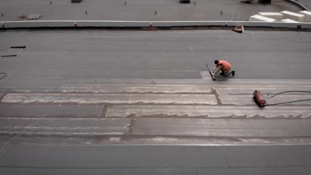 Lavoratori in un cantiere. Il processo di isolamento idroelettrico del tetto. Con l'aiuto di un materiale speciale, il tetto è coperto. lavoro — Video Stock