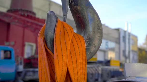 In het frame is een enorme kraanhaak. Bouwplaats, kraan op grote riemen, trekt de lading. — Stockvideo