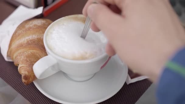 Desayuno de la mañana, croissant y capuchino. Café en la terraza de un café al aire libre . — Vídeo de stock