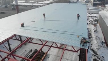 Hava atışı. havadan çekim. İşçi çerçevesinde inşaatçılar, üretim bölümünün çatı monte. Metal konstrüksiyon, bir yapı çerçevesi.