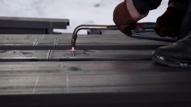 Yapıcı özel bir brülör ile metal keser. Koruyucu eldivenler