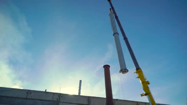 Costruire un sito industriale. Una gru gigante installa un tubo . — Video Stock