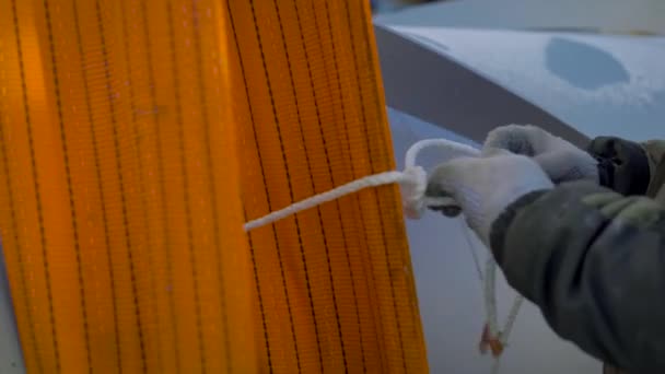 Werknemers bouwer in handschoenen banden het touw aan de stroomlijnen. Een professionele Rafter is bezig met een enorme lading — Stockvideo