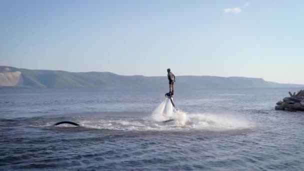 Flyboardingu je nový extrémní vodní sport. Atletický muž provádí triky v letu. Velkolepé sportovní převraty a zatáčky. — Stock video