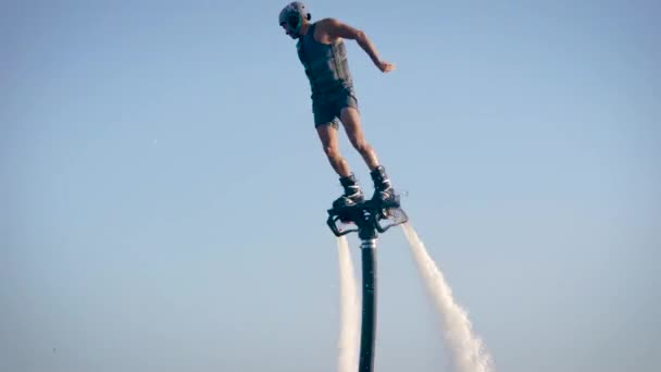 Flyboarden is een nieuwe extreme watersport. Athletic man voert trucjes uit tijdens de vlucht. Spectaculaire sport coups en bochten. — Stockvideo