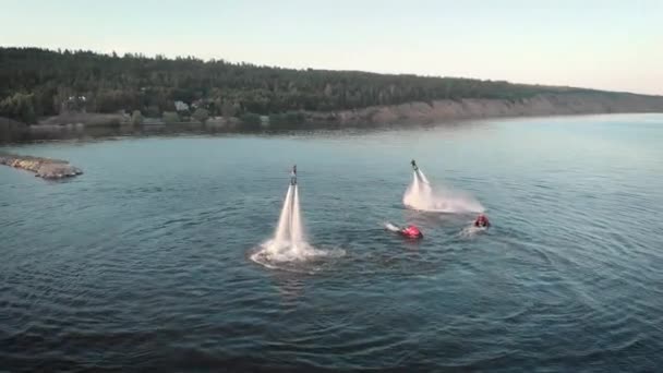 Аэросъемка Флайбординга. Два спортсмена летают на флайбордах над водой. Люди выполняют различные трюки и повороты. Водные виды спорта . — стоковое видео