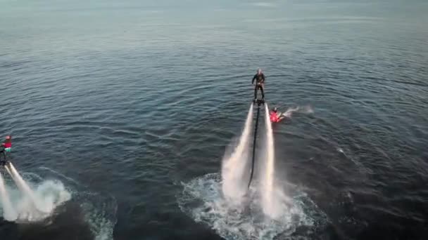 Flyboarding'in havadan çekilmiş fotoğrafı. İki atlet suyun üstündeki sinekliklerinde uçuyor. Erkekler çeşitli hileler ve dönüşler yapmak. Ekstrem su sporları. — Stok video