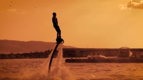 Silhouet van een man op de Fly Board bereiken voor de zon — Stockvideo